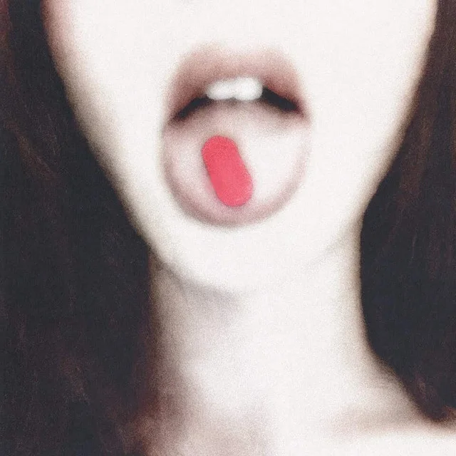 Matrix cover art: a black and white close-up of an open mouth with a red pill on the tongue.