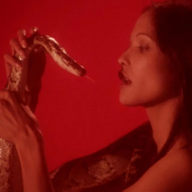 Medusa cover art: a woman holding a snake to her lips, washed in red.
