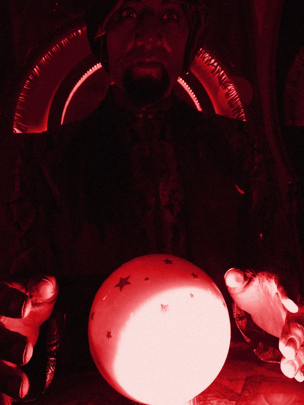 A fortune-teller animatronic behind a glowing crystal ball.