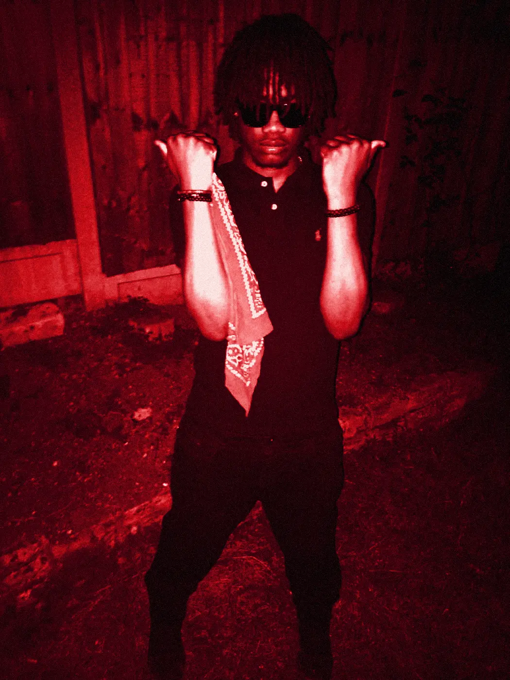 yukan in sunglasses at night in a garden, a bandana hanging from one hand.