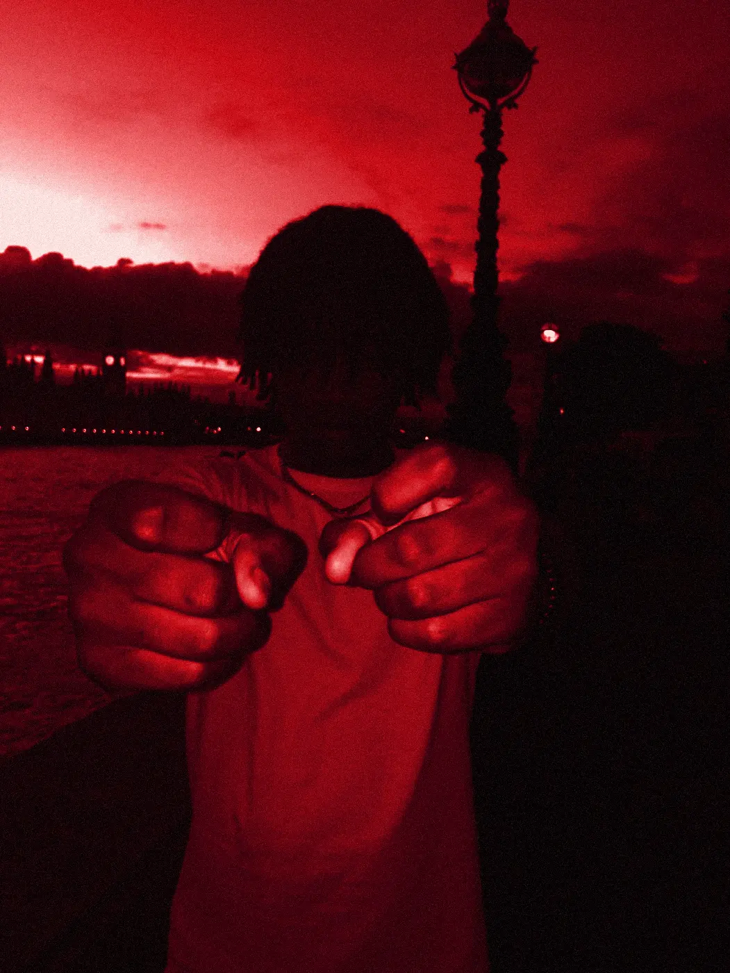 yukan by the Thames at dusk, both fists pushed toward the camera.