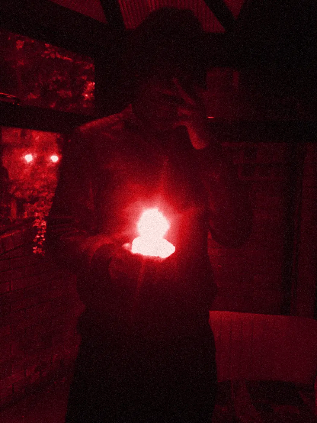 yukan in the dark holding a small flame in his palm.